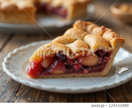 Delicious slice of a fruit pie with a golden crust on a white plate 124132999