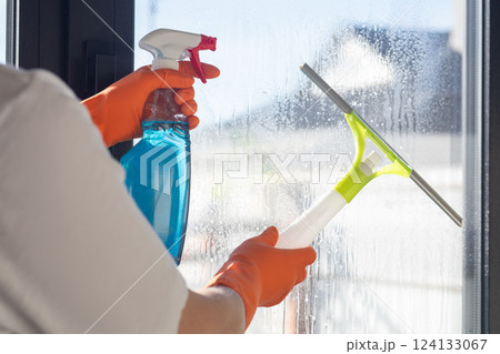 Using a special squeegee and cleaner to clean windows. 124133067