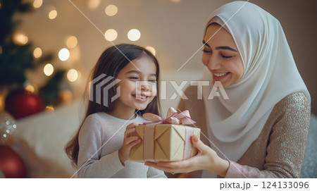 A loving mother and daughter exchanging a gift 124133096