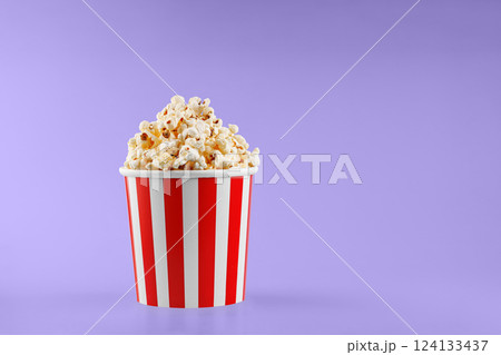 Classic red striped popcorn cardboard cup on Purple, violet background Classic red striped popcorn cardboard cup on Purple, violet background 124133437