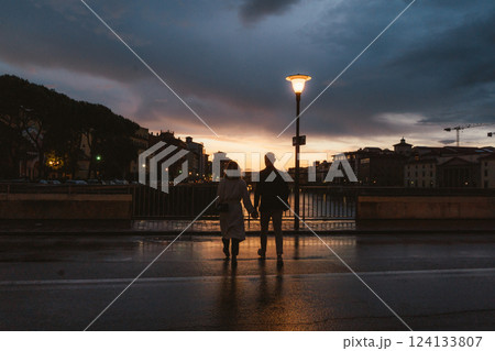 Couple Holding Hands at Sunset Stroll by the River 124133807