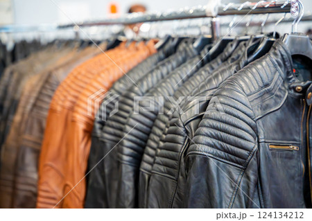 Row of leather motorcycle jackets neatly displayed, highlighting rugged style and protective gear for riders. Concept of biker fashion, durability, and essential safety apparel. 124134212