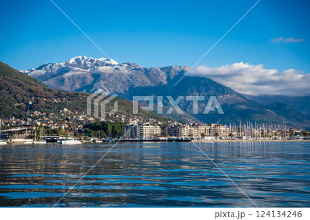Bay of Kotor in Montenegro and the top of high snow-capped mountains, small settlements on the coast and the bright blue waters of the Adriatic Sea. 124134246