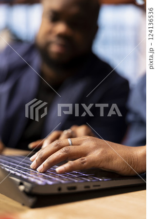 African American man and woman sits at a stylish home office, brainstorming ideas for their digital business, using modern technology to improve communication and project efficiency. 124136536