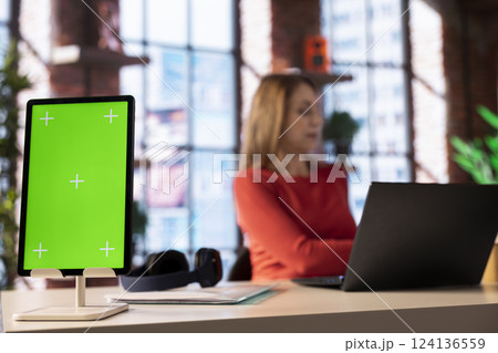 Ambitious person learning a new language alone next to copy space display in her loft apartment, browsing web for study platforms. Woman using a language learning software online on her laptop. 124136559