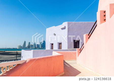 Colorful Mina village district street with arab traditional shaped buildings and modern downtown in the background, Doha, Qatar 124136618