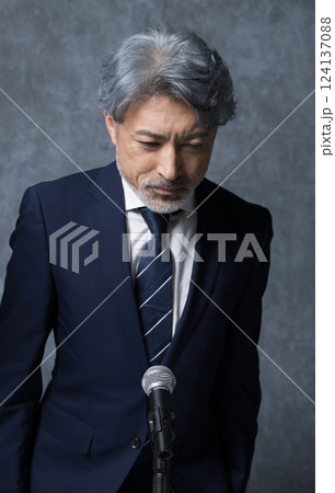 謝罪会見や株主総会などのお辞儀するビジネスイメージ　頭を下げる経営者や社長のイメージ	 124137088