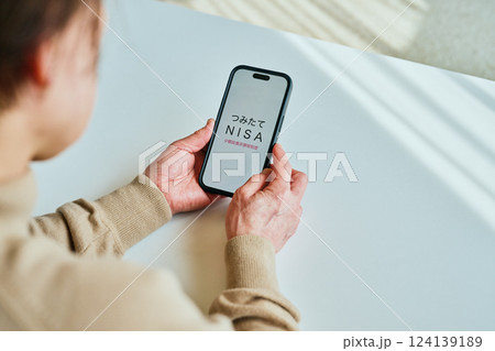 スマホを操作するシニア女性 つみたてNISA スマホを操作するシニア女性 つみたてNISA 124139189