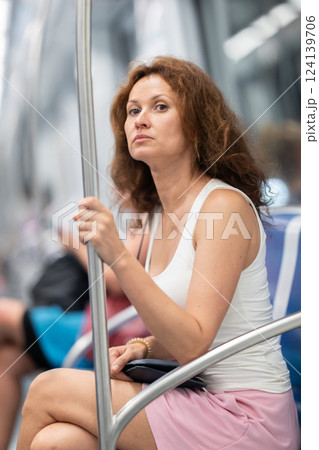 Adult woman sitting in subway car Adult woman sitting in subway car 124139706
