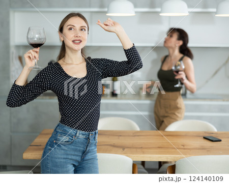 Woman enthusiastically dances in kitchen and enjoys encouraging news. Woman enthusiastically dances in kitchen and enjoys encouraging news. 124140109