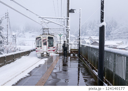【ほくほく線】真冬の駅を発車する列車 124140177
