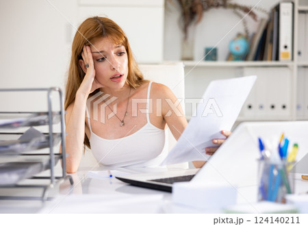 Portrait of tired woman bookkeeper sitting at table 124140211