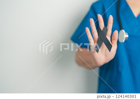 Melanoma and skin cancer, Vaccine injury awareness month and rest in peace concepts. doctor holding black Ribbon 124140301