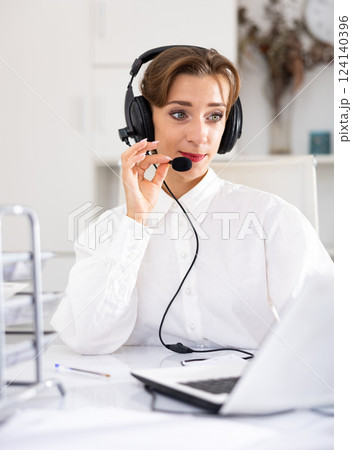 Cheerful woman with headset working in call center Cheerful woman with headset working in call center 124140396