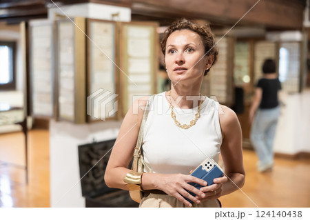 Thoughtful woman examining historacal exhibits in museum 124140438