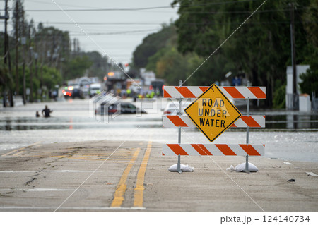 Hurricane Debby flooded street with road closed sign blocking driving of cars in Sarasota, Florida. Safety of transportation during natural disaster concept 124140734