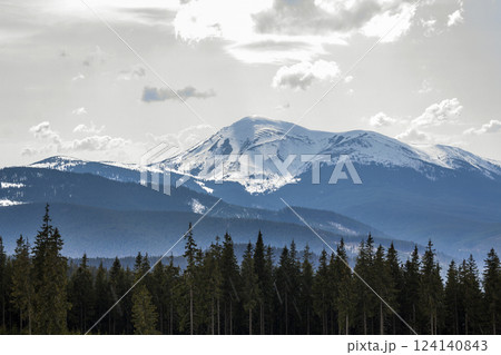 Fantastic view of mountain Petros in Carpathian mountains range on bright sunny spring day. Sharp contrast between dark pine forest and bright shiny snow on tops. Beauty and power of nature concept. Fantastic view of mountain Petros in Carpathian mountains range on bright sunny spring day. Sharp contrast between dark pine forest and bright shiny snow on tops. Beauty and power of nature concept. 124140843