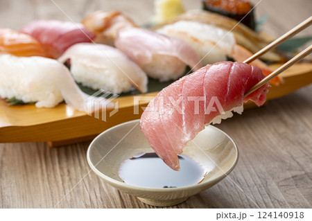 皿に盛られた美味しそうな寿司を箸でつまむ 124140918