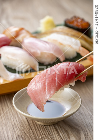 皿に盛られた美味しそうな寿司を箸でつまむ 皿に盛られた美味しそうな寿司を箸でつまむ 124140920