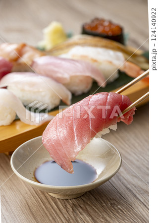 皿に盛られた美味しそうな寿司を箸でつまむ 皿に盛られた美味しそうな寿司を箸でつまむ 124140922