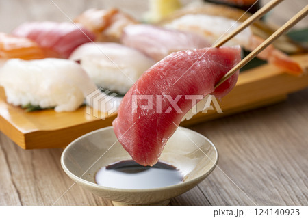 皿に盛られた美味しそうな寿司を箸でつまむ 124140923