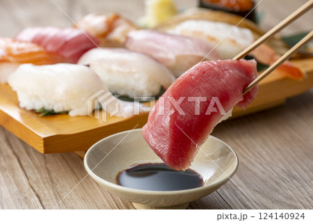 皿に盛られた美味しそうな寿司を箸でつまむ 皿に盛られた美味しそうな寿司を箸でつまむ 124140924