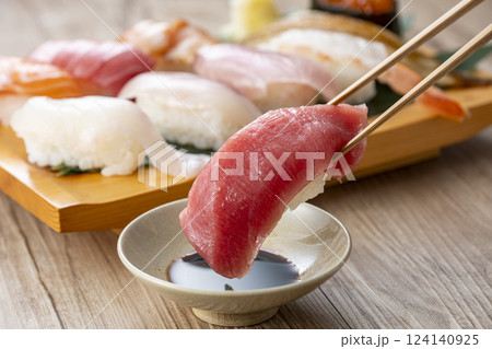 皿に盛られた美味しそうな寿司を箸でつまむ 皿に盛られた美味しそうな寿司を箸でつまむ 124140925