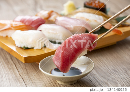 皿に盛られた美味しそうな寿司を箸でつまむ 124140926