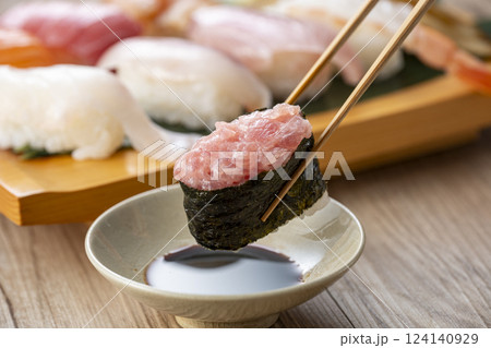 皿に盛られた美味しそうな寿司を箸でつまむ 124140929
