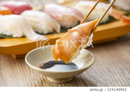 皿に盛られた美味しそうな寿司を箸でつまむ 皿に盛られた美味しそうな寿司を箸でつまむ 124140942