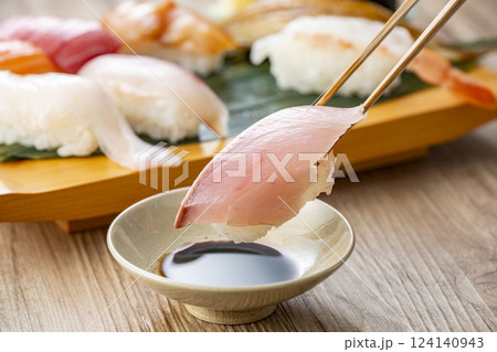 皿に盛られた美味しそうな寿司を箸でつまむ 124140943