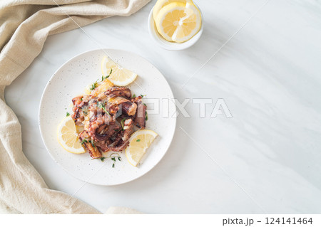 grilled octopus or squid with butter lemon sauce 124141464