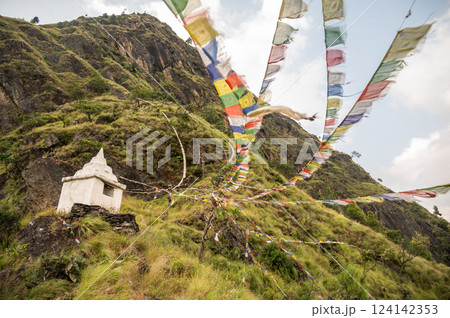 Prayer flags blowing by the wind on the small hill in Syabrubesi village a beautiful resident village inside the Langtang National Park of Nepal. 124142353