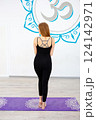 Woman in black sportswear standing on a yoga mat 124142971