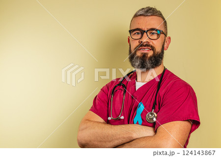Happy male medical assistant in scrubs poses confidently in clinic 124143867
