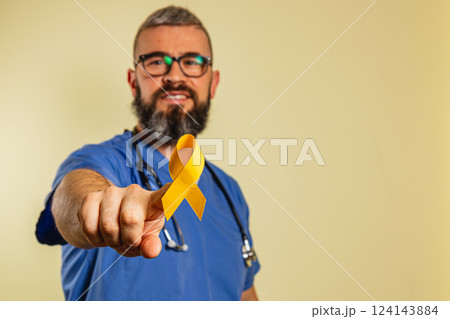 Healthcare professional shares hope with a yellow ribbon in a clinic setting 124143884