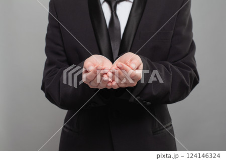 A man in a suit is holding his hands out in a gesture of surrender A man in a suit is holding his hands out in a gesture of surrender 124146324