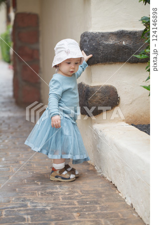 Pretty little baby girl toddler in blue dress, outdoor portrait 124146898