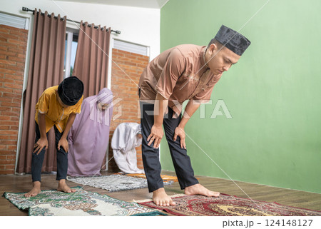 Portrait of an Indonesian muslim family praying (salat) together. Concept of Islamic praying or Ramadan Kareem 124148127