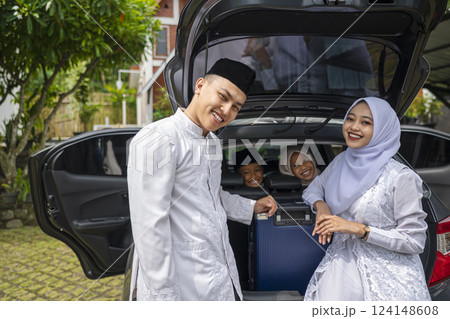 Asian Muslim family ready to mudik or travel to hometown by car. Concept of Eid Al Fitr, Idul Fitri, Lebaran, and Ramadan Mubarak celebration 124148608