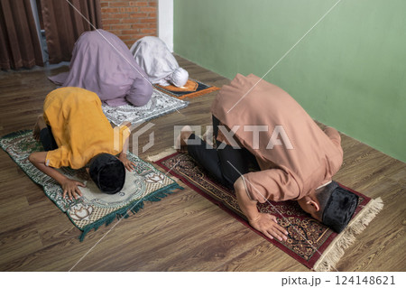 Portrait of an Indonesian muslim family praying (salat) together. Concept of Islamic praying or Ramadan Kareem Portrait of an Indonesian muslim family praying (salat) together. Concept of Islamic praying or Ramadan Kareem 124148621