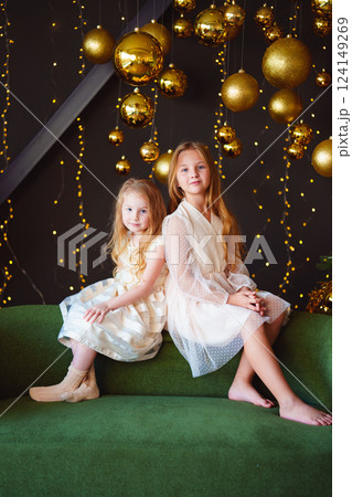 Two happy cute sisters in the New Year's decor of the room. Two happy cute sisters in the New Year's decor of the room. 124149269