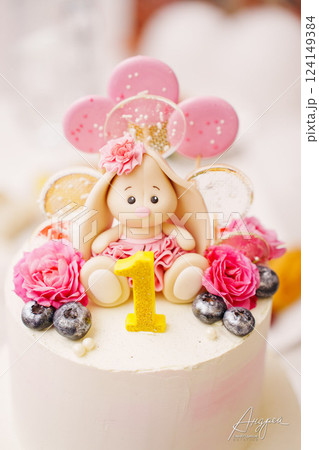 Children's festive two-tiered cake decorated with flowers and a bunny for a girl 124149384