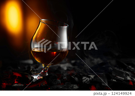 Snifter of brandy on a burning charcoal. Snifter of brandy on a burning charcoal. 124149924
