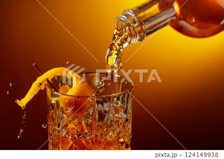 Whiskey or bourbon pouring into a crystal glass. 124149938