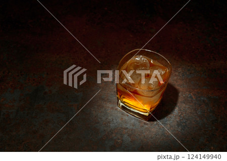 Whiskey in a square glass with ice on a vintage background. 124149940