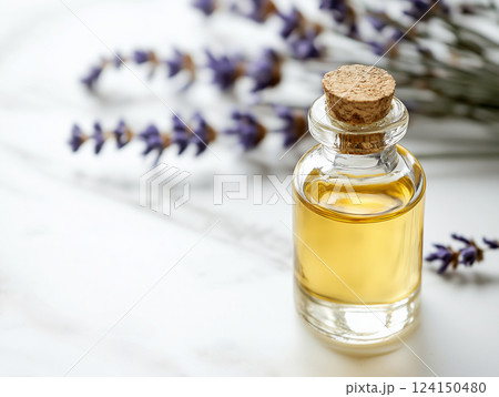 Small glass bottle of golden essential oil with a cork stopper, placed on a marble surface Small glass bottle of golden essential oil with a cork stopper, placed on a marble surface 124150480