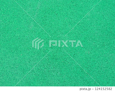 green single color textured grainy background material close-up full frame, rubber crumb coating for sports and fitness and for paving playgrounds, soft springy elastic artificial material 124152582