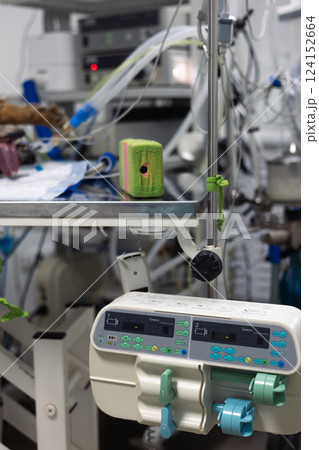 Monitors of controlling vital indicators and a dispenser for intravenous injection are located next to the operating table. The dog lies on a surgical table under anesthesia connected to apparatuses. Monitors of controlling vital indicators and a dispenser for intravenous injection are located next to the operating table. The dog lies on a surgical table under anesthesia connected to apparatuses. 124152664