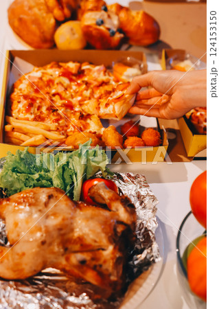 Happy young friends group having lunch at home. Asia family party eating pizza food and laughing enjoying meal while sitting at dining table together at house. Celebration holiday and togetherness. Happy young friends group having lunch at home. Asia family party eating pizza food and laughing enjoying meal while sitting at dining table together at house. Celebration holiday and togetherness. 124153150